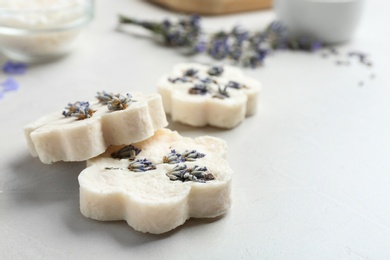 Photo of Hand made soap bars with lavender flowers on white table, closeup. Space for text