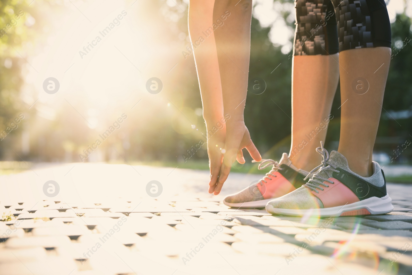 Photo of Woman stretching before morning run in park, closeup. Space for text