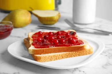 Slice of bread with jam on white marble table