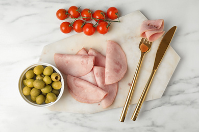 Photo of Tasty ham served on white marble table, flat lay