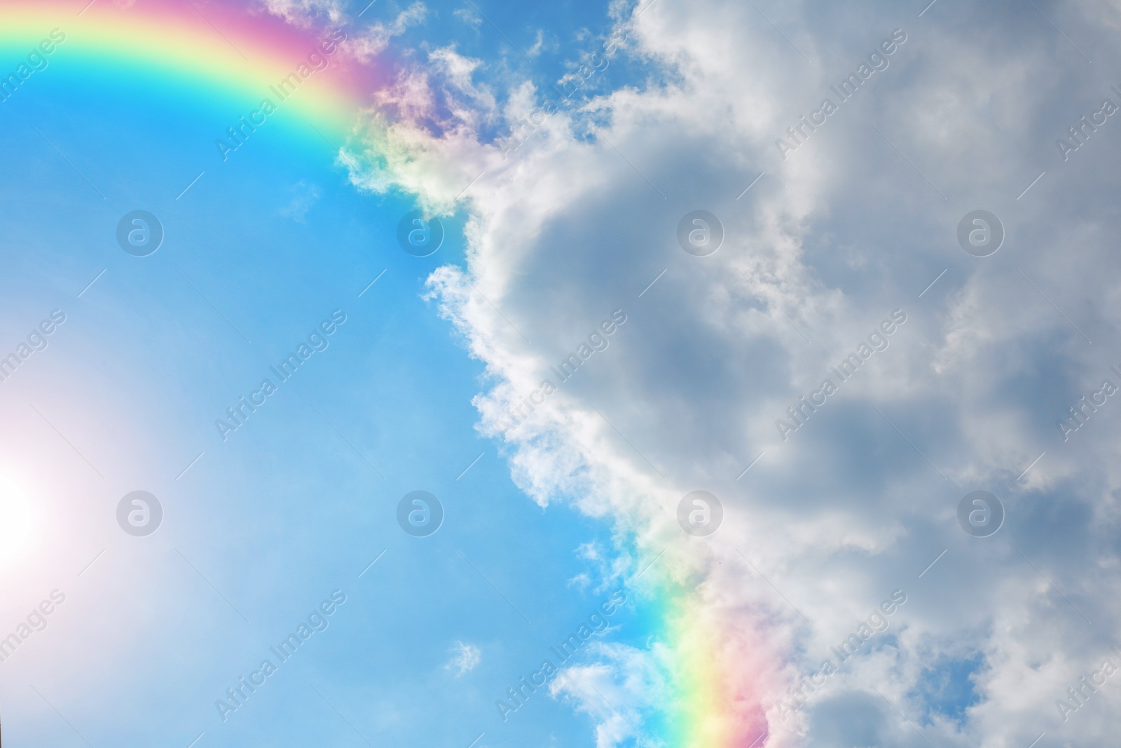 Image of Picturesque view of beautiful rainbow and blue sky on sunny day 