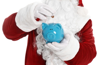 Photo of Santa Claus putting coin into piggy bank on white background, closeup