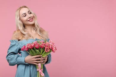 Happy young woman with beautiful bouquet on dusty pink background. Space for text