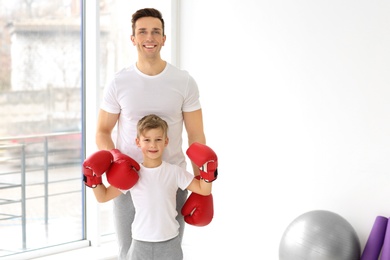 Photo of Happy dad and his son in gym