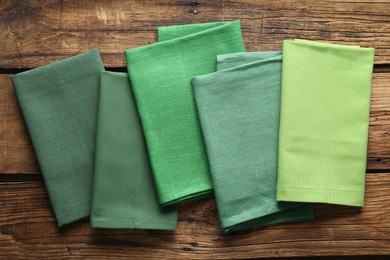 Photo of Different kitchen napkins on wooden table, flat lay
