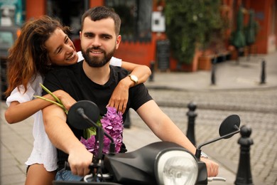 Photo of Beautiful young couple riding motorcycle on city street