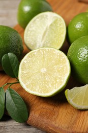 Photo of Fresh ripe limes on wooden table, closeup