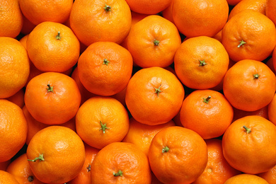 Photo of Delicious fresh ripe tangerines as background, top view