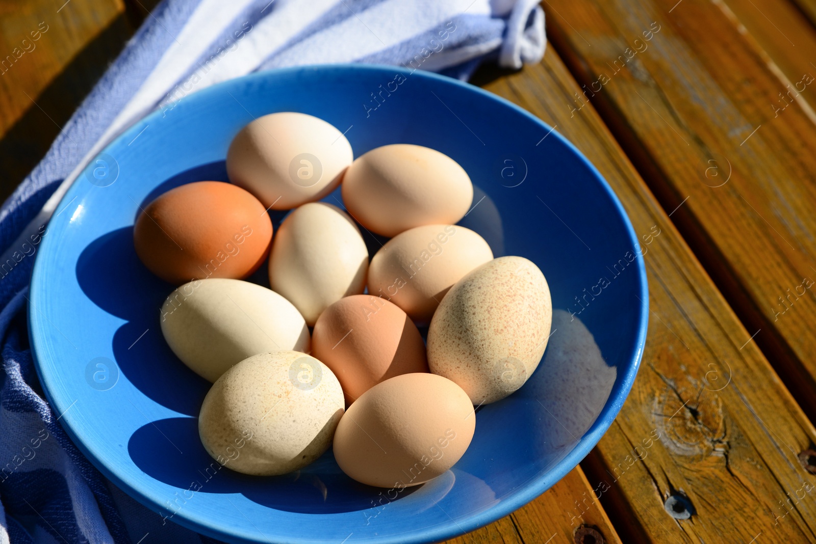 Photo of Plate of assorted eggs and napkin on wooden table