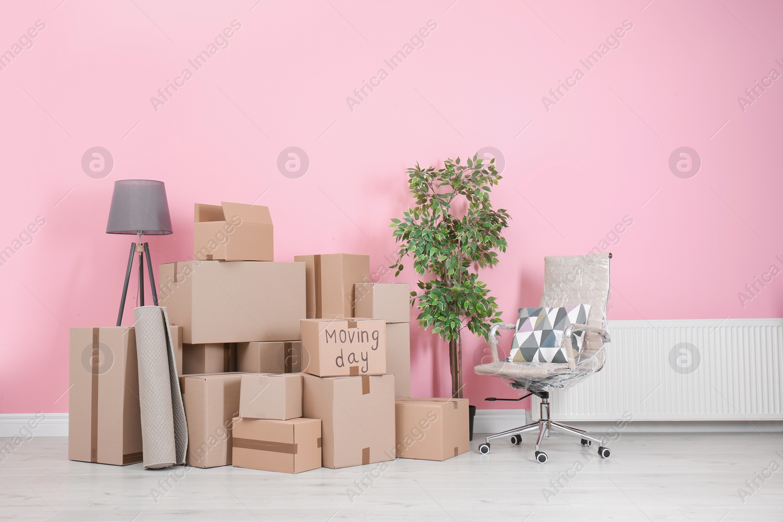 Photo of Cardboard boxes and household stuff in empty room. Moving day