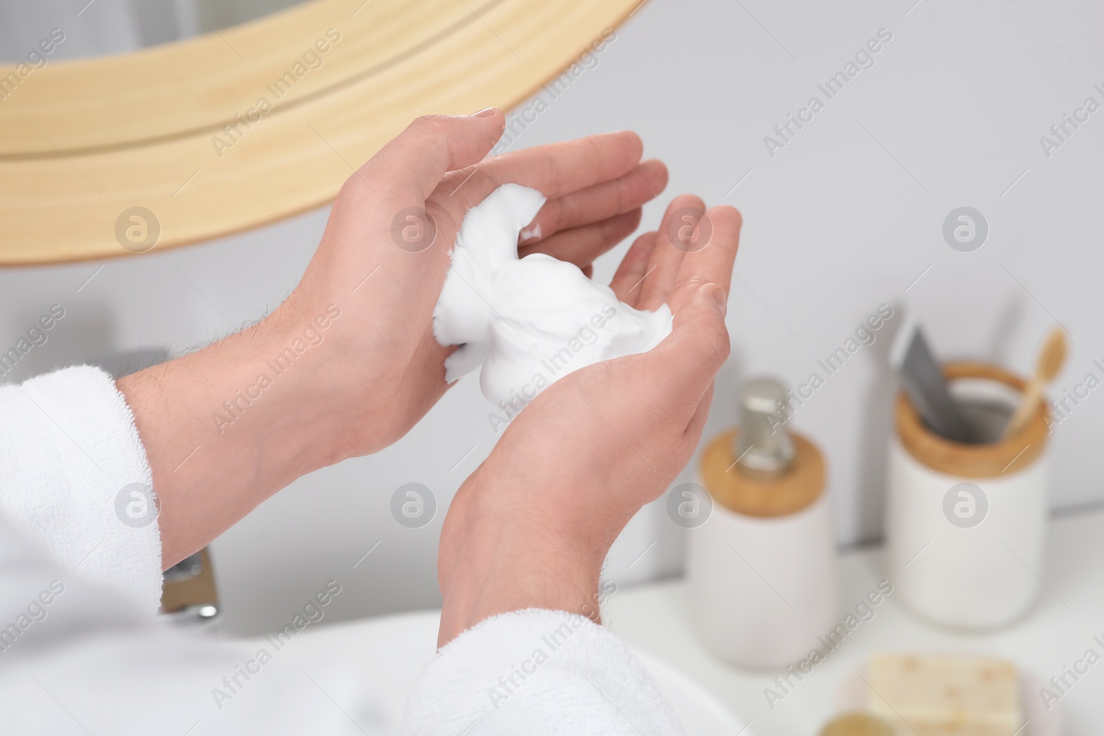 Photo of Man holding shaving foam in bathroom, closeup