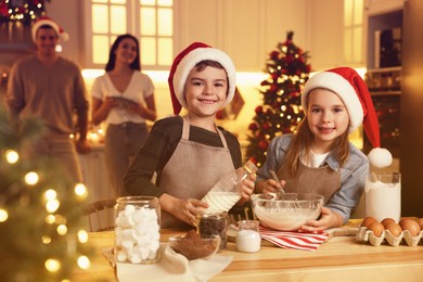 Photo of Cute little children making dough for delicious Christmas cookies at home