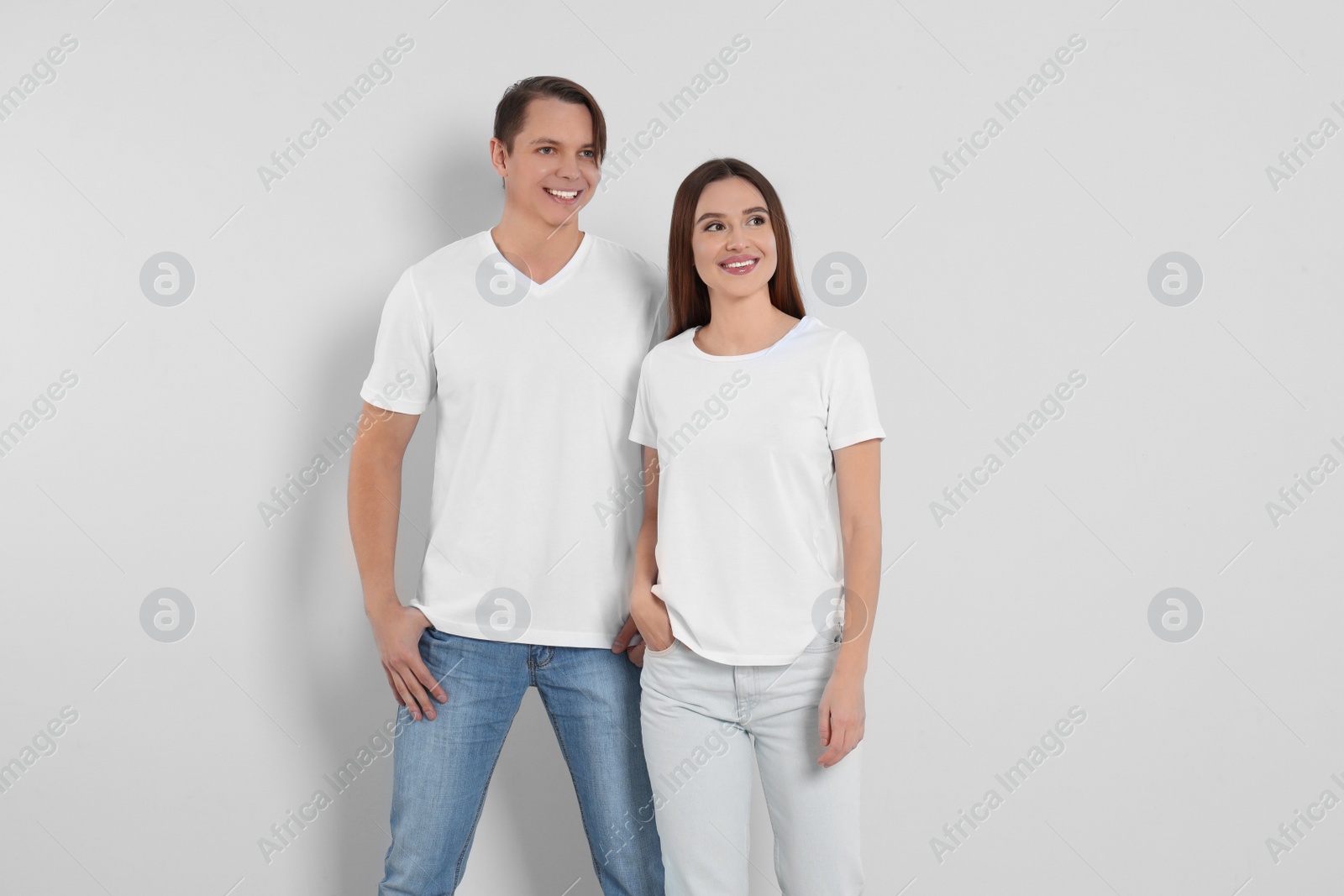 Photo of Young couple in stylish jeans on light background