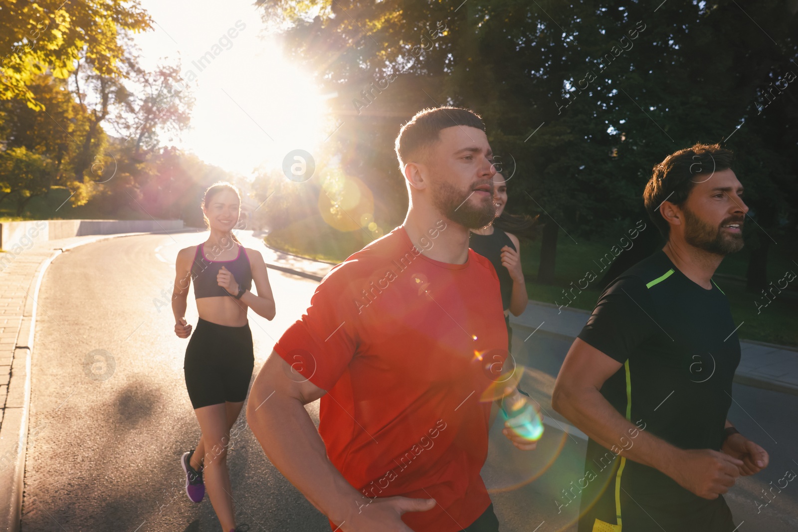 Photo of Group of people running outdoors on sunny day