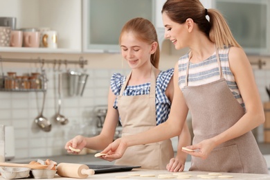 Photo of Mother and her daughter with cookie dough in kitchen