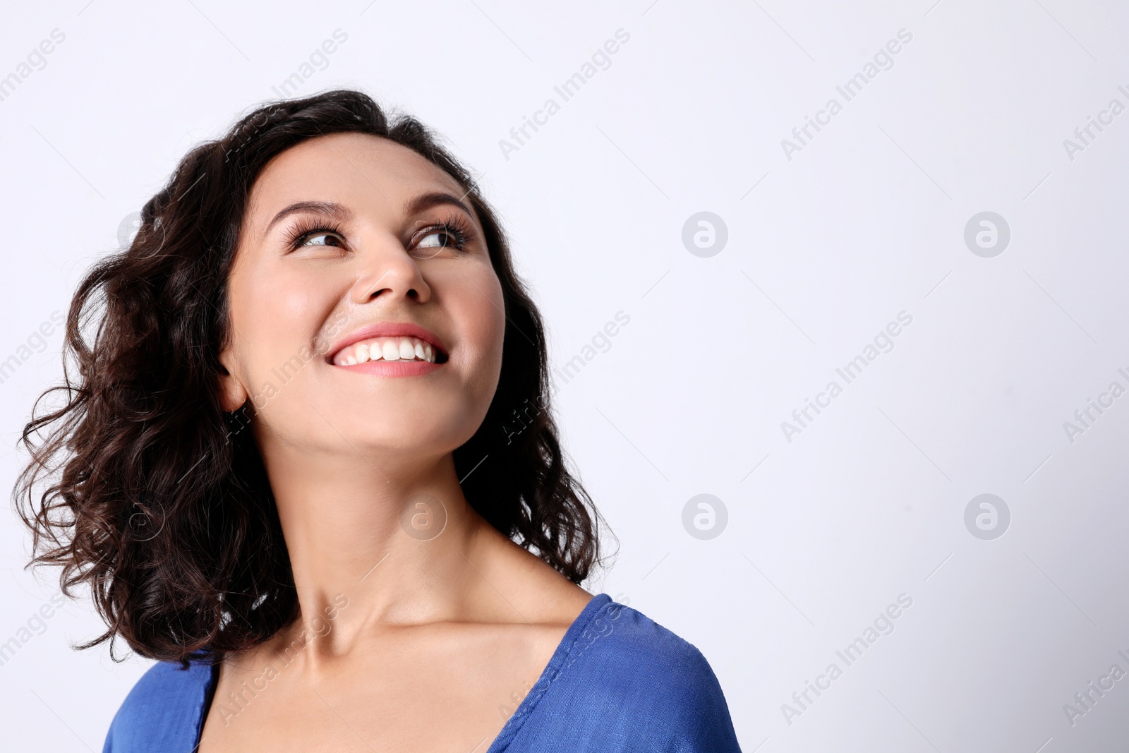 Photo of Happy young woman in casual outfit on light background. Space for text