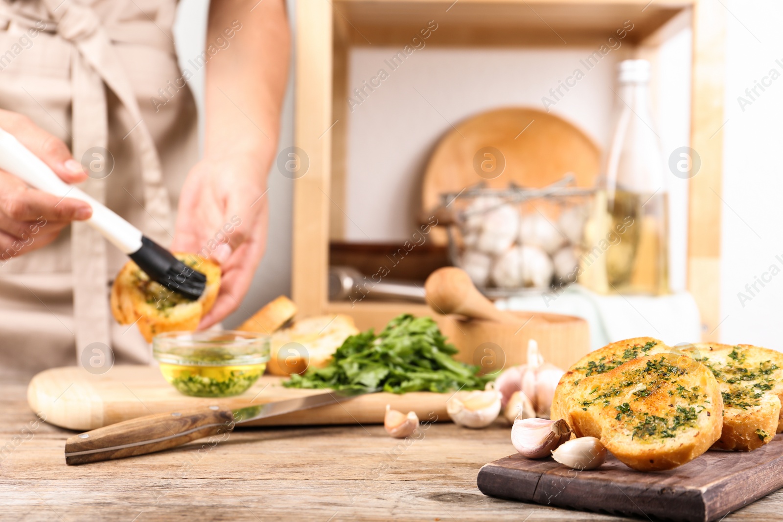 Photo of Slices of toasted bread with garlic and blurred woman on background. Space for text