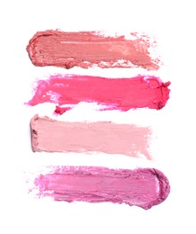 Photo of Smears of different beautiful lipsticks on white background, top view
