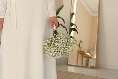 Photo of Bride with beautiful bouquet indoors, closeup view. Wedding day