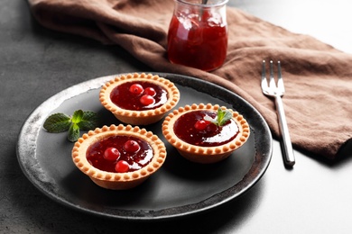 Tasty tartlets with jam on plate