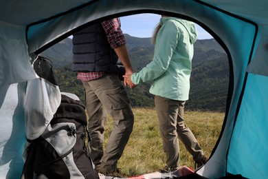 Photo of Couple in mountains on sunny day, view from camping tent
