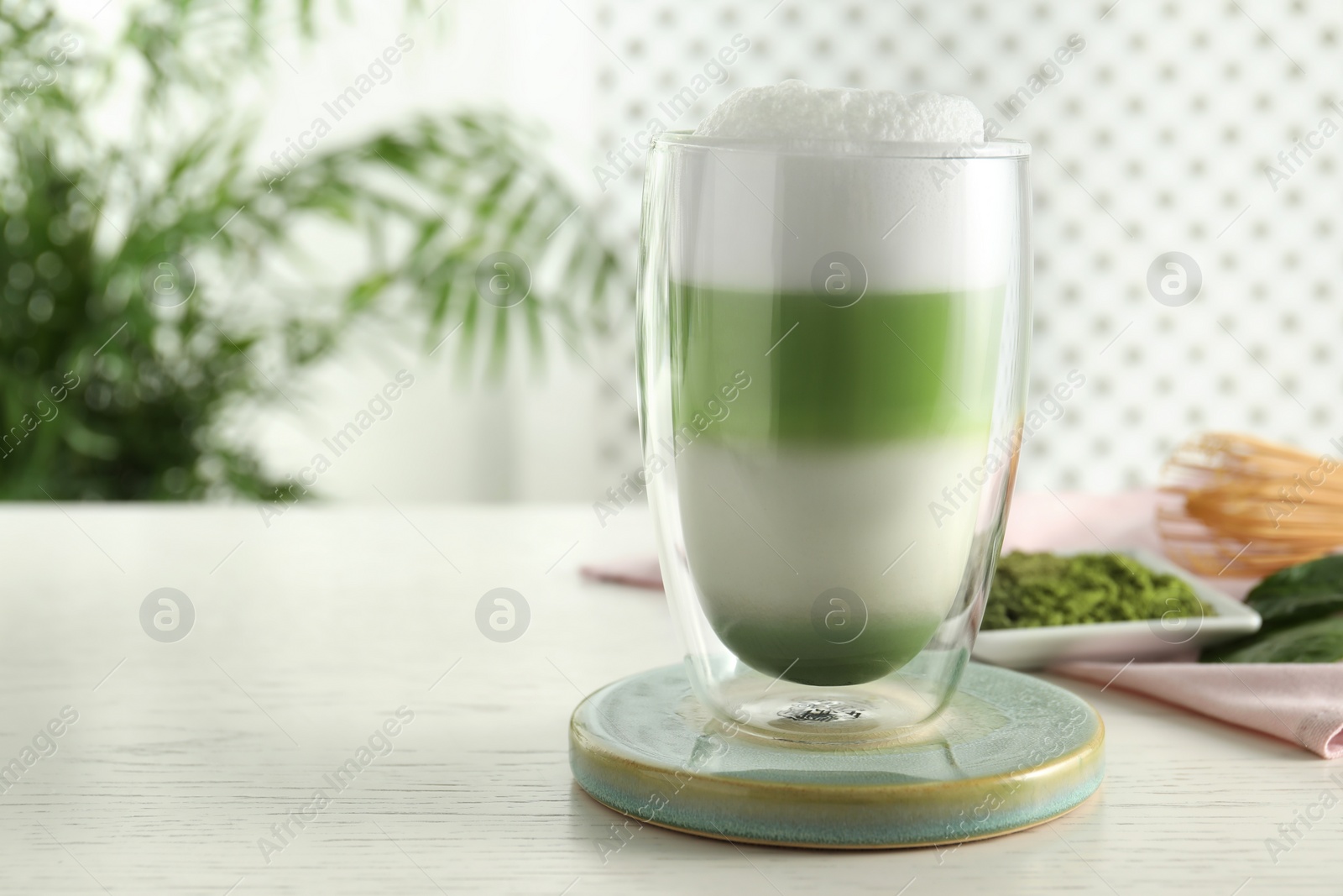 Photo of Glass of tasty matcha latte on light grey table. Space for text