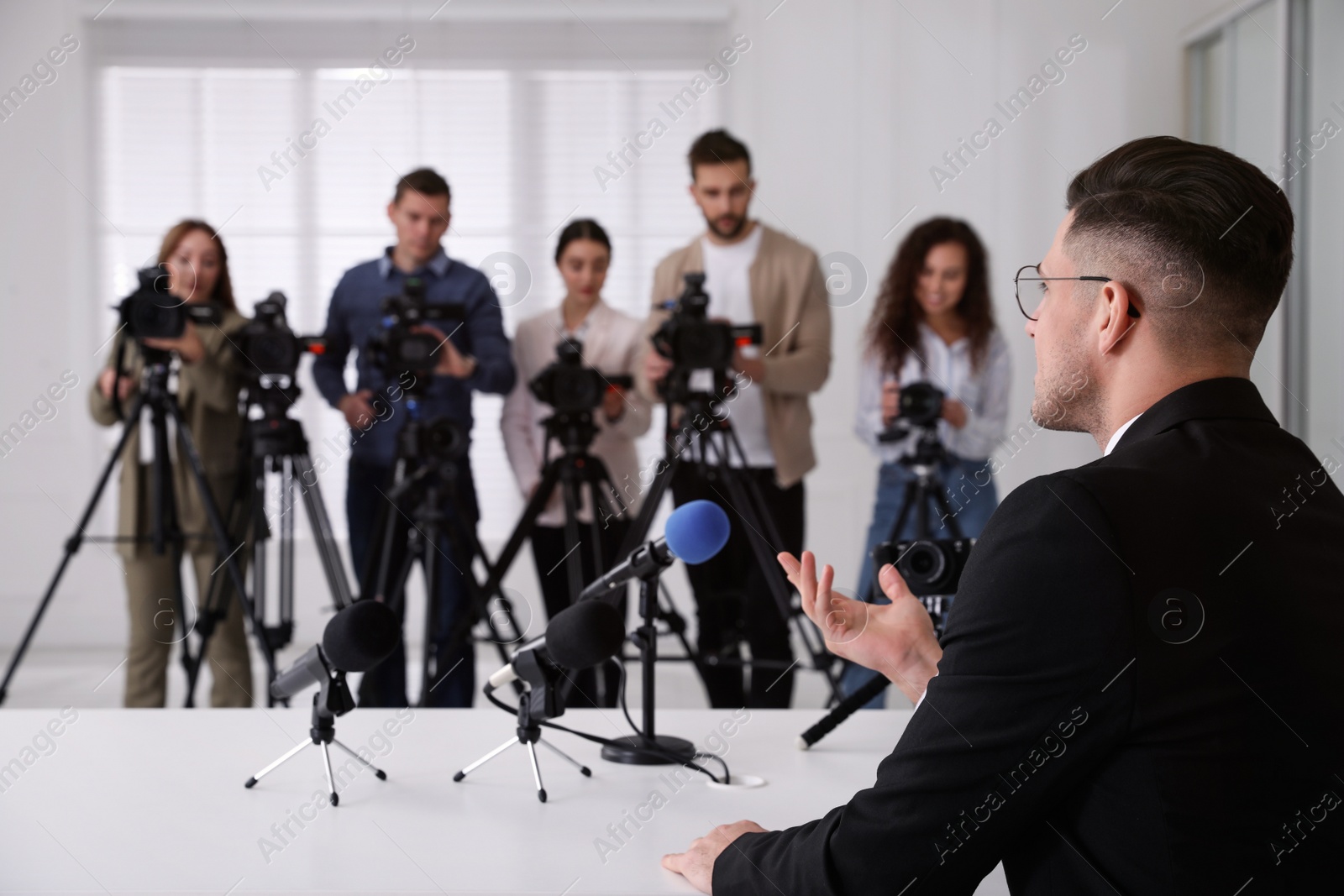 Photo of Businessman giving interview to journalists at official event