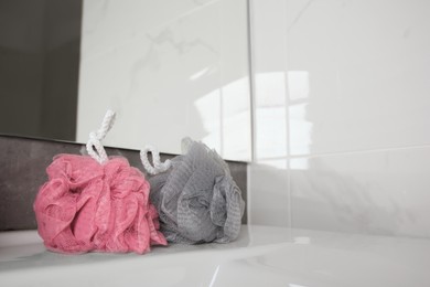 Colorful shower puffs on sink in bathroom, space for text