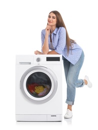 Photo of Young woman near washing machine with laundry on white background