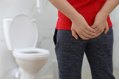 Photo of Boy suffering from hemorrhoid in rest room, closeup