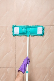 Man cleaning floor with mop, top view