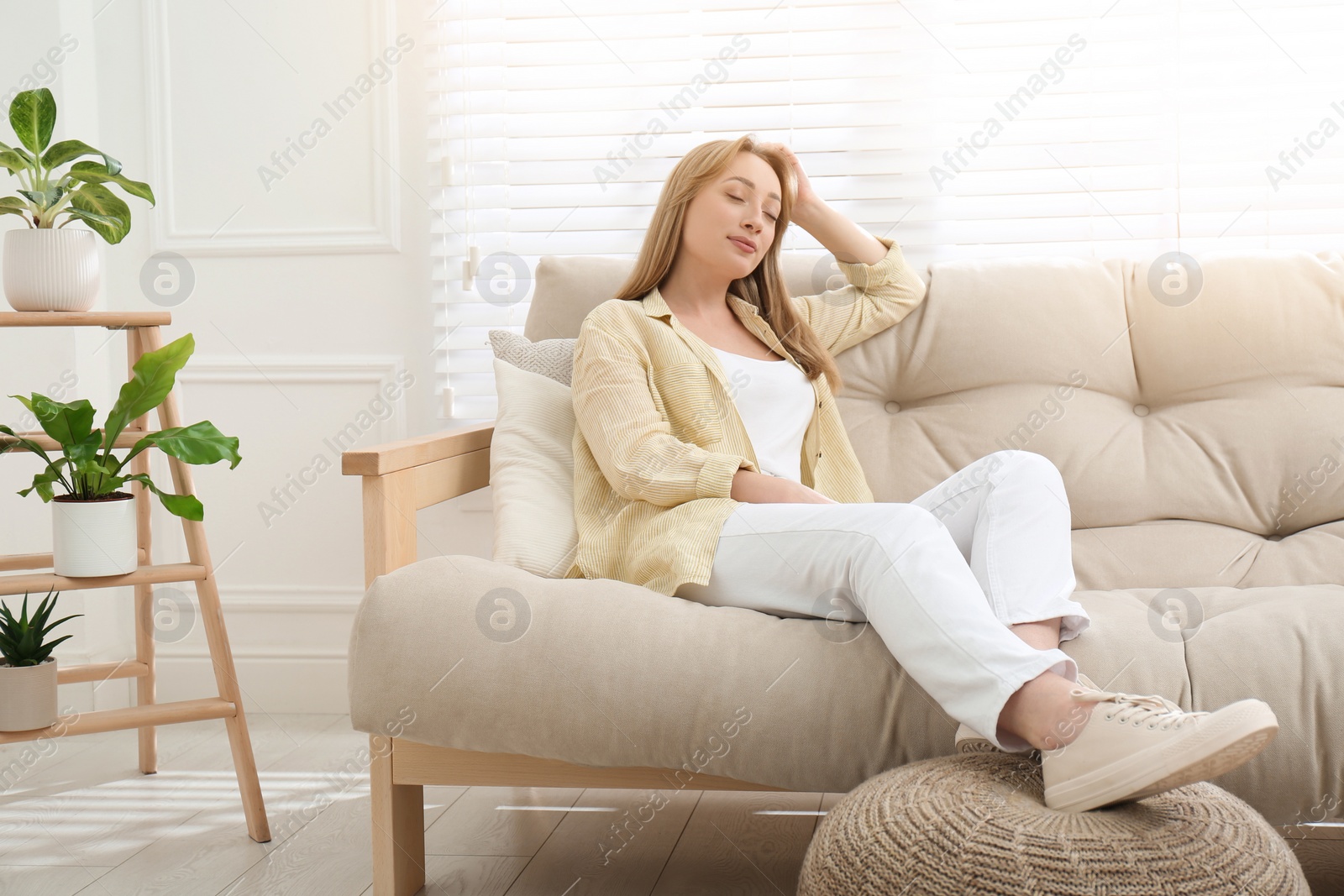 Photo of Beautiful young woman relaxing on sofa at home