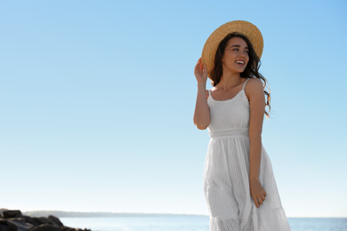 Photo of Happy young woman with beach hat near sea