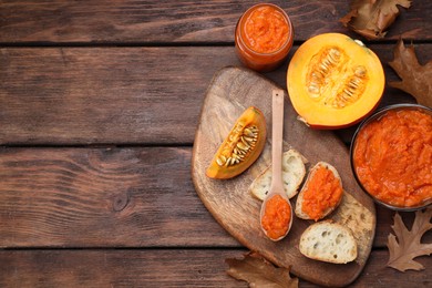 Photo of Slices of bread with delicious pumpkin jam and fresh pumpkin on wooden table, flat lay. Space for text