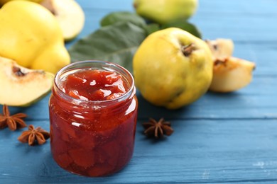 Delicious quince jam on blue wooden table, closeup