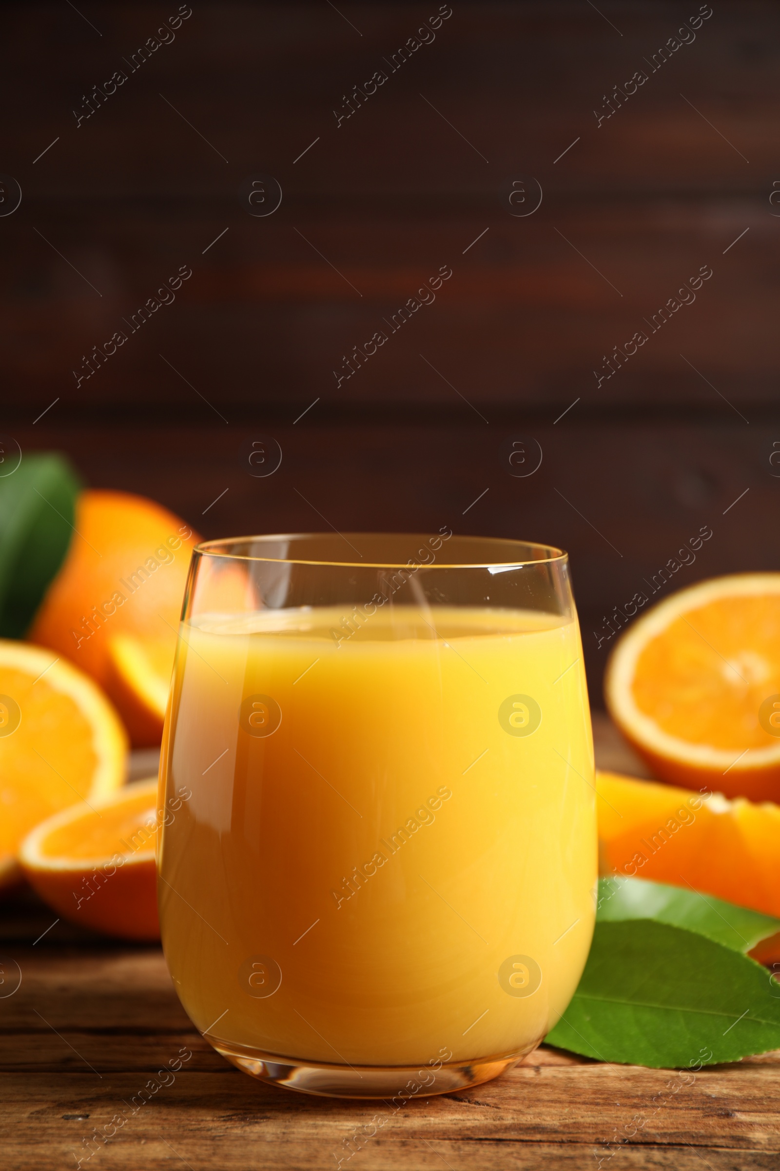 Photo of Glass of orange juice and fresh fruits on wooden table