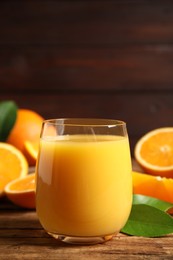 Glass of orange juice and fresh fruits on wooden table