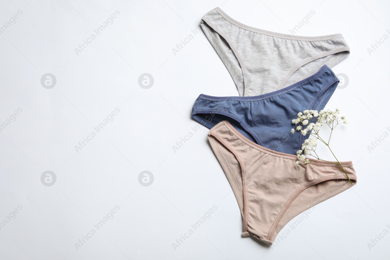 Photo of Women's underwear and flowers on white background, flat lay