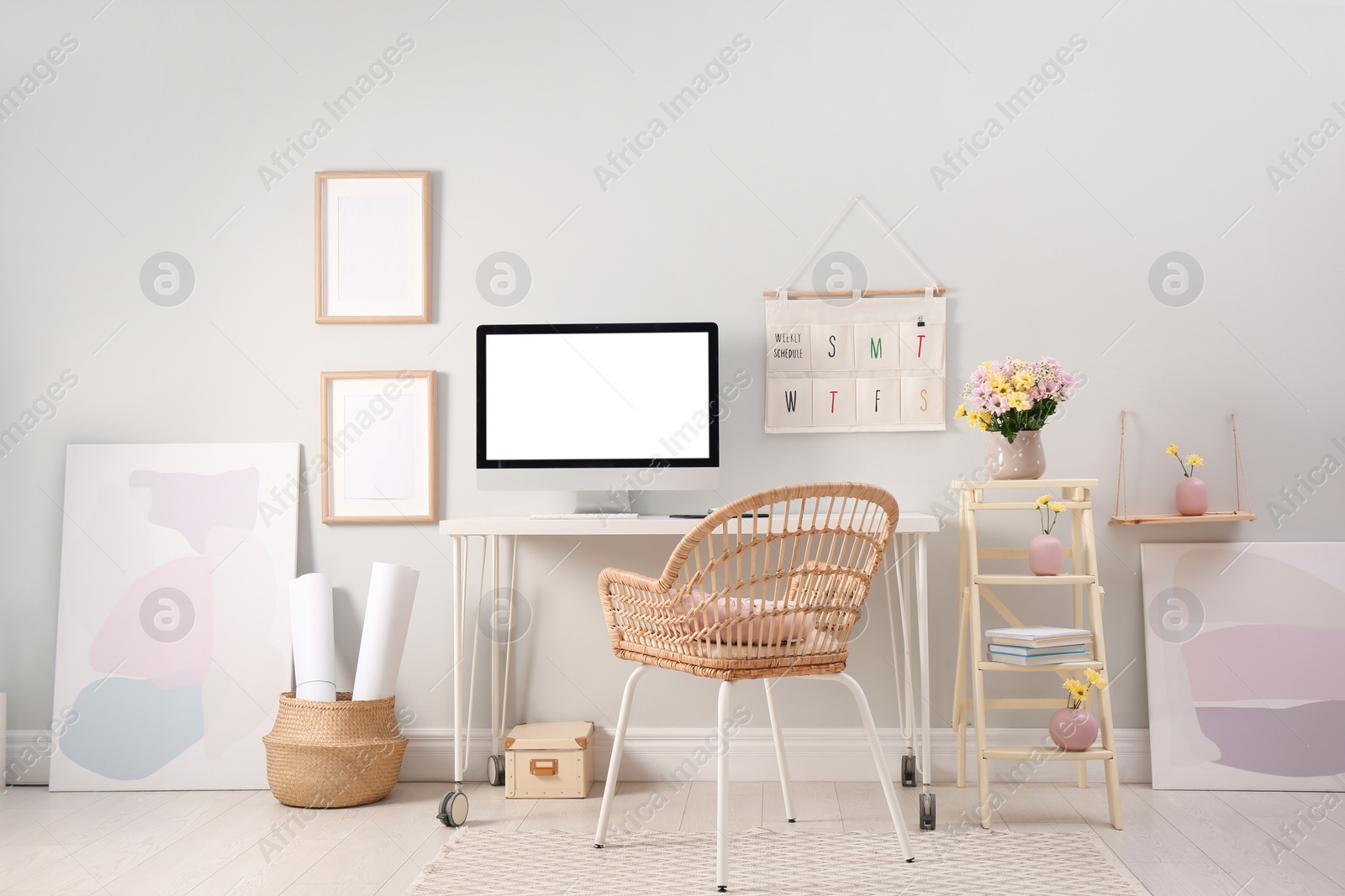 Photo of Comfortable workplace with modern computer and flowers in room. Interior design