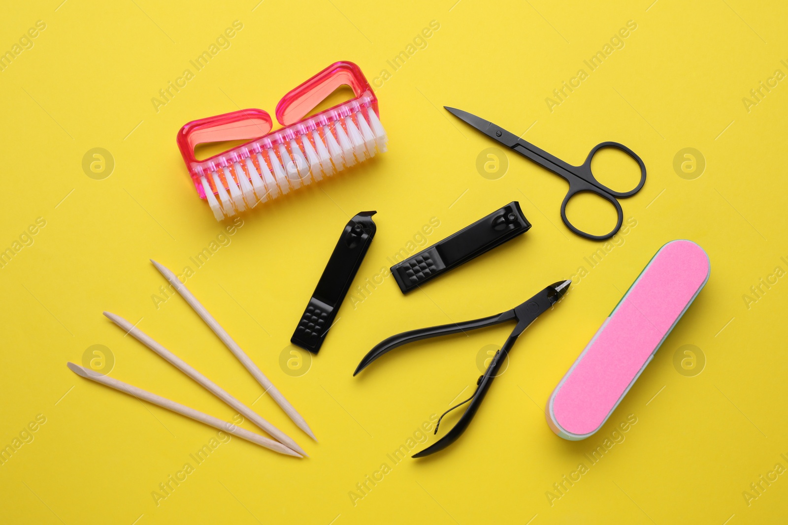 Photo of Set of pedicure tools on yellow background, flat lay