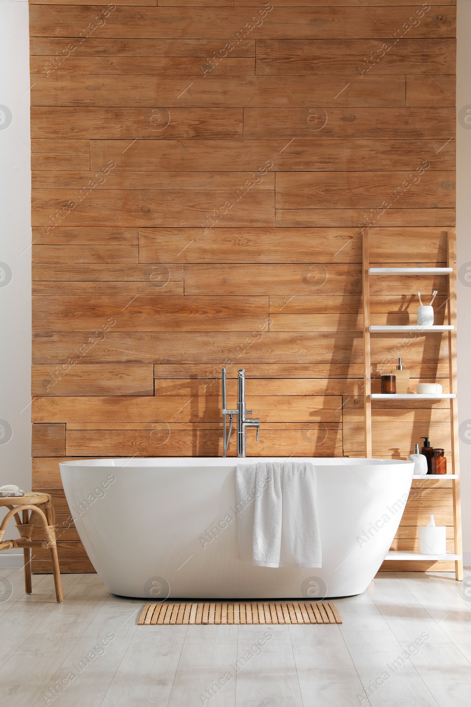 Photo of Bathroom interior with white tub and decor near wooden wall