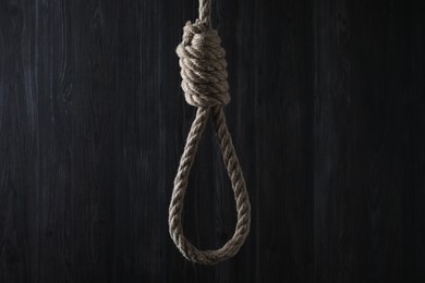 Tied rope noose against dark wooden background