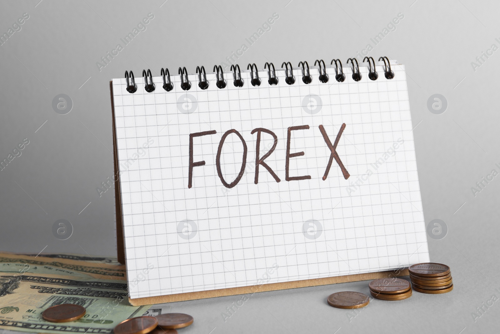 Photo of Notebook with word Forex, coins and banknotes on grey background