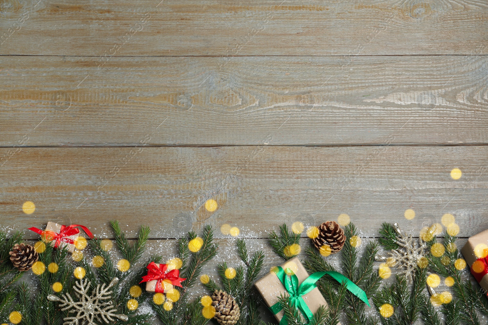 Photo of Christmas greeting card with space for text. Flat lay composition of fir tree branches and festive decor on wooden background