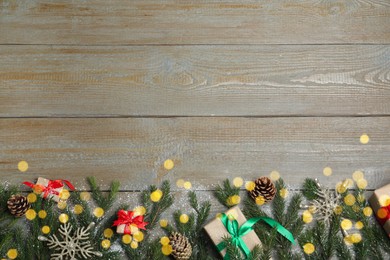 Christmas greeting card with space for text. Flat lay composition of fir tree branches and festive decor on wooden background