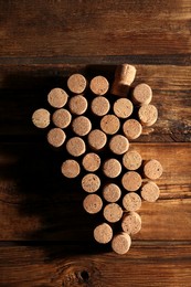 Grape made of wine bottle corks on wooden table, top view