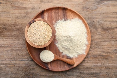 Photo of Pile of quinoa flour and seeds in bowl on wooden table, top view