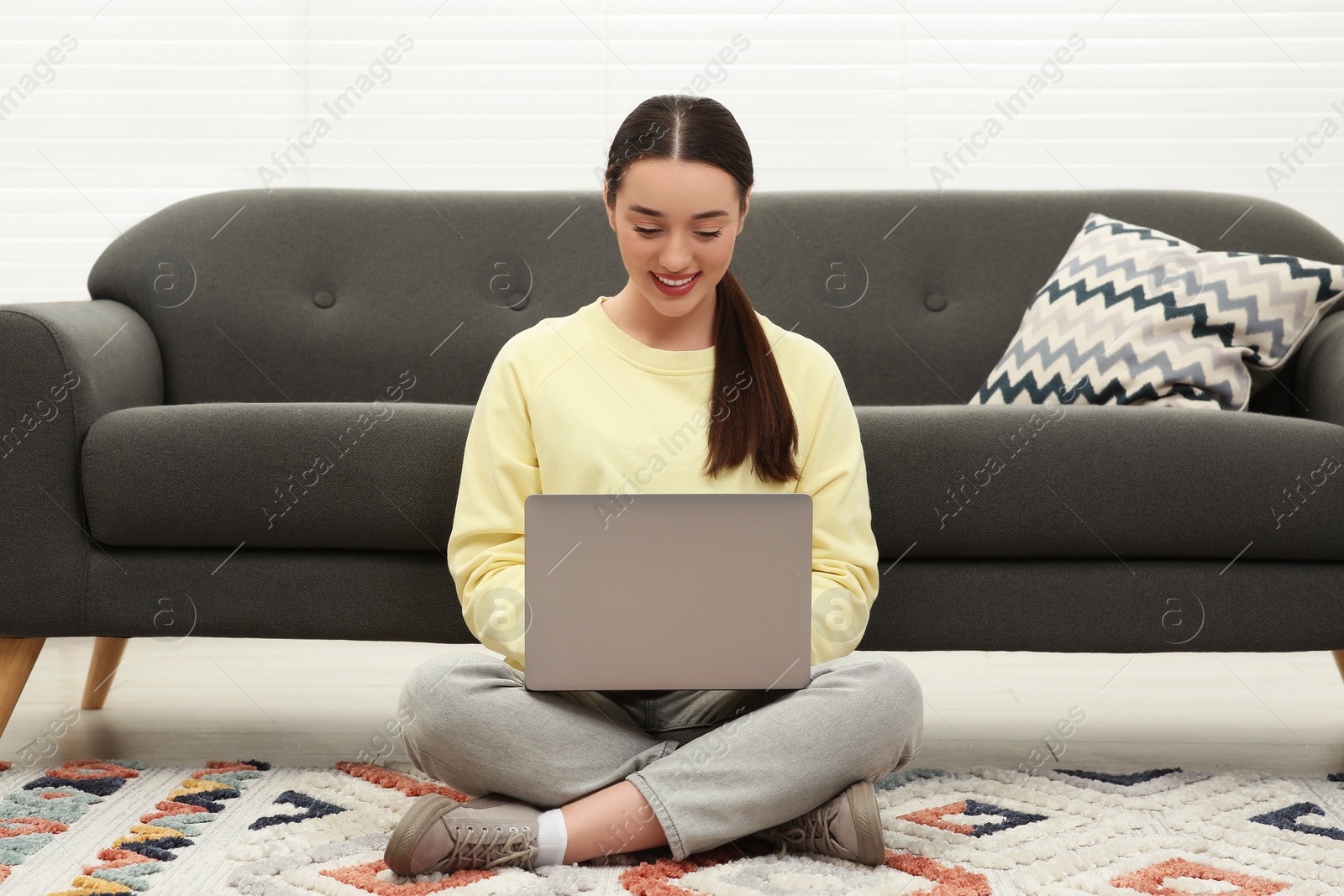 Photo of Woman using laptop on floor at home