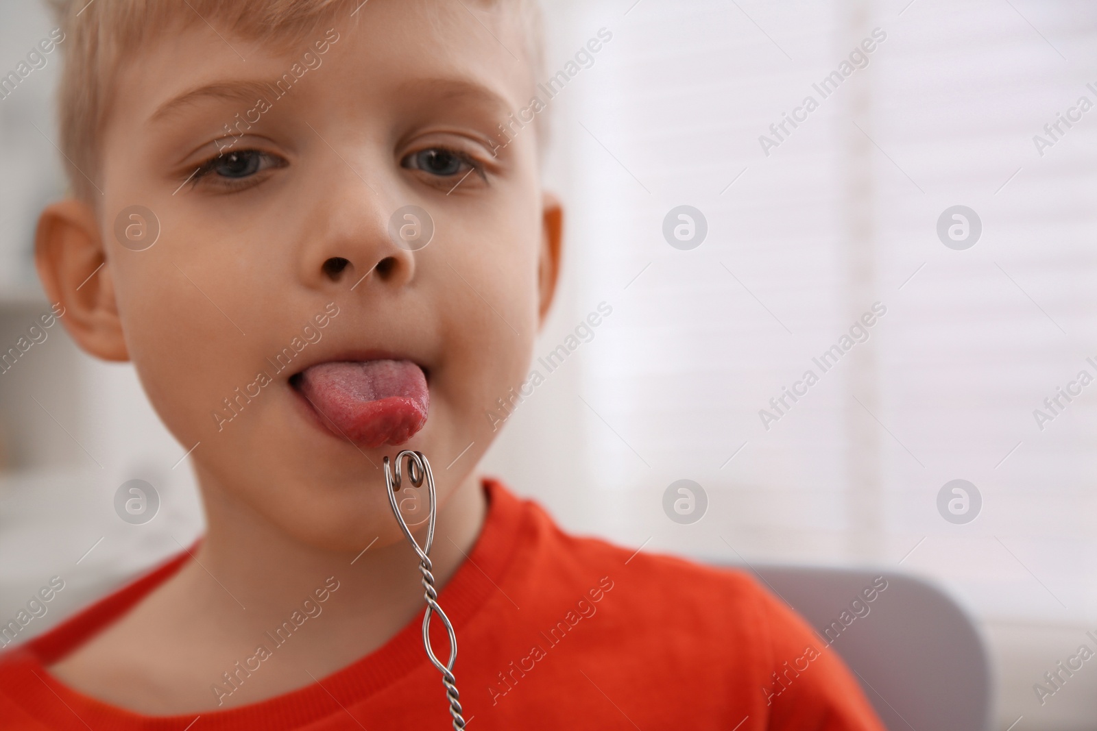 Photo of Little boy doing exercise with logopedic probe at speech therapist office, closeup