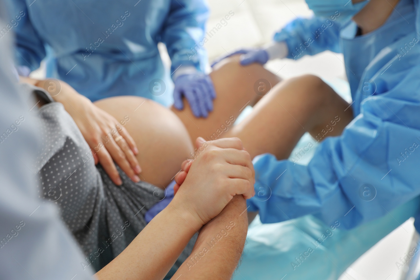 Photo of Woman giving child birth in maternity hospital, closeup